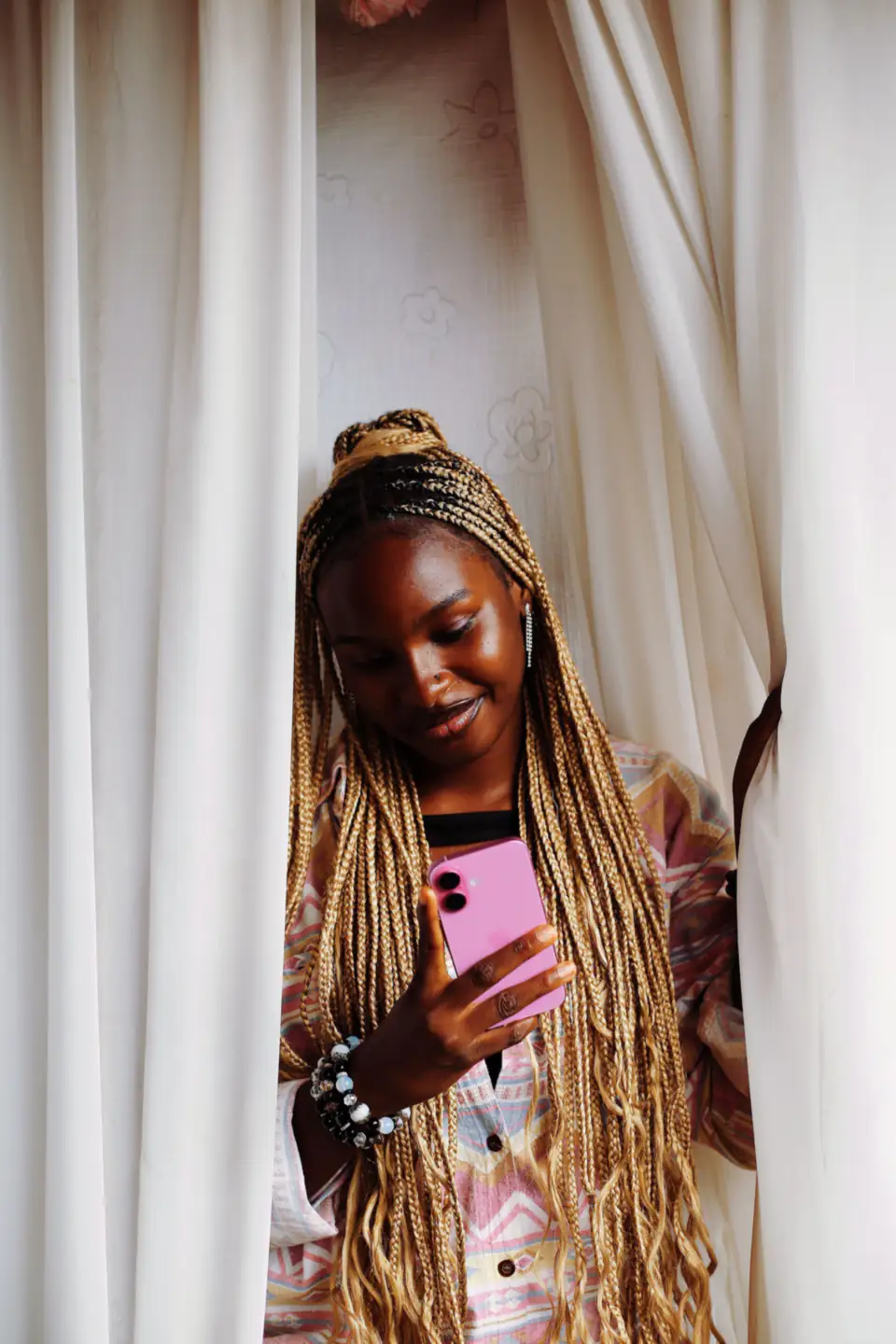 Une jeune femme sourit en regardant son téléphone