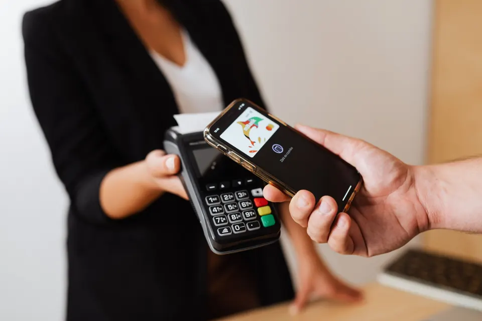 Un client paie avec son téléphone sur un terminal de paiement