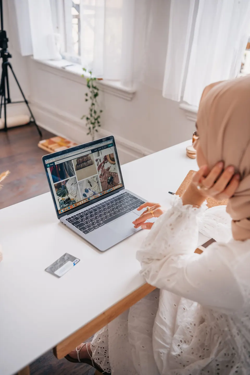 Une vendeuse en hijab parcourt sa boutique en ligne sur son ordinateur